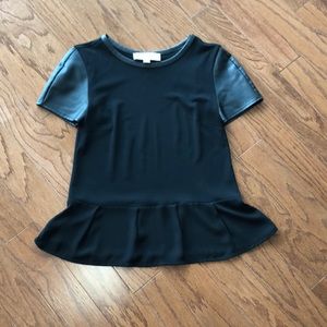 Black blouse with patent leather sleeves.